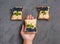 Female hand holds a homemade sandwich with cottage cheese, blueberries, banana, mint on a dark background