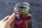 Female hand holds mason jar mug with fresh cool detox drink with raspberries, blueberries. Lemonade in a glass with a mint. The