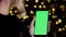 Female hand holds mobile phone with chromakey vertical green screen mockup pov