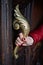 Female hand holds ornate brass door handle