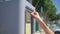 Female hand inserts coins into the Parking meter to pay for Parking space