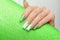 Female hand with long nails with glitter nail polish. Long green nail design. Women hand with sparkle manicure on glitter