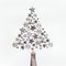 Female hand make Christmas tree with wooden stars and decorative snowflakes on white background. Top view. Creative holiday