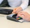 Female hand makes payment via bank terminal