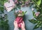 Female hand making beautiful bouquet of pink flowers on florist workspace, top view. Woman wrap bouquet in wrapping paper