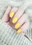 Female hand manicure winter closeup bstyle eauty yellow sweater decoration