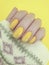 Female hand manicure winter polish closeup beauty yellow sweater decoration