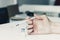 Female hand with a medical syringe and bottle with insulin for diabetes on white table