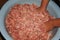 Female hand mixes a lot of ground beef in a metal pan in the kitchen. Cooking cutlets steaks. Minced meat in bowl, meat patties.