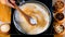 Female hand mixing the Semiya into a pan of boiling milk with a wooden spatula