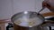 Female Hand is Mixing Spaghetti, Pasta in Saucepan of Boiling Water a Spoon
