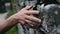 A female hand moves along a stone wall, close-up.