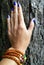 Female hand nail with beads wood background