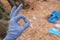 female hand ok in a glove on the background of polluted nature