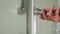 Female hand opens the door in the shower cabin. Woman hold handle bathroom cabin with right hand. Detail of a modern