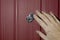 A female hand opens the shutter on the door peephole in the front door. The concept of security