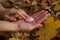 Female hand with orange manicure holding pink quartz yoni egg for vumfit, imbuilding or meditation on yellow fallen