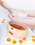 Female hand orange parrafin wax in bowl. Manicure beauty spa salon