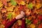 Female hand over autumn leaves background. Nail design concept