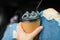 Female hand with paper cup of coffee take away. Girl in torn jeans holds Coffee to go in her hands