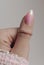 Female hand with pastel pink nail and with beautiful stylish ring on finger. Close up photo. Nail polish
