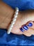 Female hand with pearls bracelet blue background