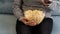 Female hand picking popcorn from paper bucket closeup. Close up of woman eating pop corn at cinema. Movie food concept