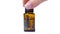 Female hand put Doterra essential oil in dark glass bottle with aroma herbs on white table