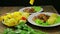 Female hand puts slices of vegetables in a plate with green salad and chicken