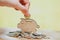 Female hand putting coin and stack of coins in concept of savings and money growing or energy save.