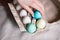 Female hand putting colorful easter egg on egg box