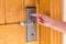 Female hand putting and holding magnetic key card switch in to open hotel room door