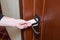 Female hand putting key card switch in to open hotel room door. Holding magnetic card for door access control scanning key card