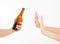 Female hand reject a bottle of beer isolated on white background.anti alcohol concept. Copy space