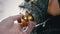 A Female Hand Rotates a Shiny Yellow Christmas Ball Hanging on a Christmas Tree