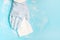 Female hand in rubber glove wipes surface with rag, blue background