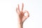 Female hand showing the gesture from contacting each other index finger and thumb is isolated on a white background