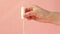 Female hand shows a tampon on a pink background. Women health concept, zero waste alternatives