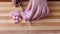 Female hand slicing raw ham cubes on cutting board