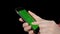 Female hand sliding green screen on mobile phone. Woman holding smartphone in hands and touching green chromakey screen