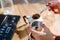 A female hand with spoon of ground coffee is filled with a geyser coffee maker