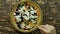 Female hand sprinkle seasoning from wooden spoon on vegetarian low calorie Greek salad. top view Close-up