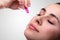 Female Hand Squeezing Vitamin Capsule On Face