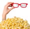 Female hand sticks out of a pile of popcorn isolated on white background