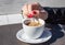 Female hand stirring  coffee with a teaspoon in an outdoor cafe