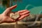 A female hand with a stone in the shape of a heart in front of a blurred background