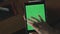 Female hand swiping green screen tablet. Close up tablet with chroma key screen