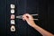 Female hand takes chopsticks sushi rolls with Chinese chopsticks. Lying on a black wooden board. View from above