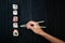 Female hand takes chopsticks sushi rolls with Chinese chopsticks. Lying on a black wooden board. View from above