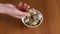 Female Hand Takes One Quail Egg from the Plate, Examines it in Hand. Close-up